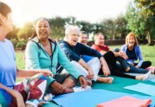 Happy senior people after yoga sport class having fun sitting outdoors in park city